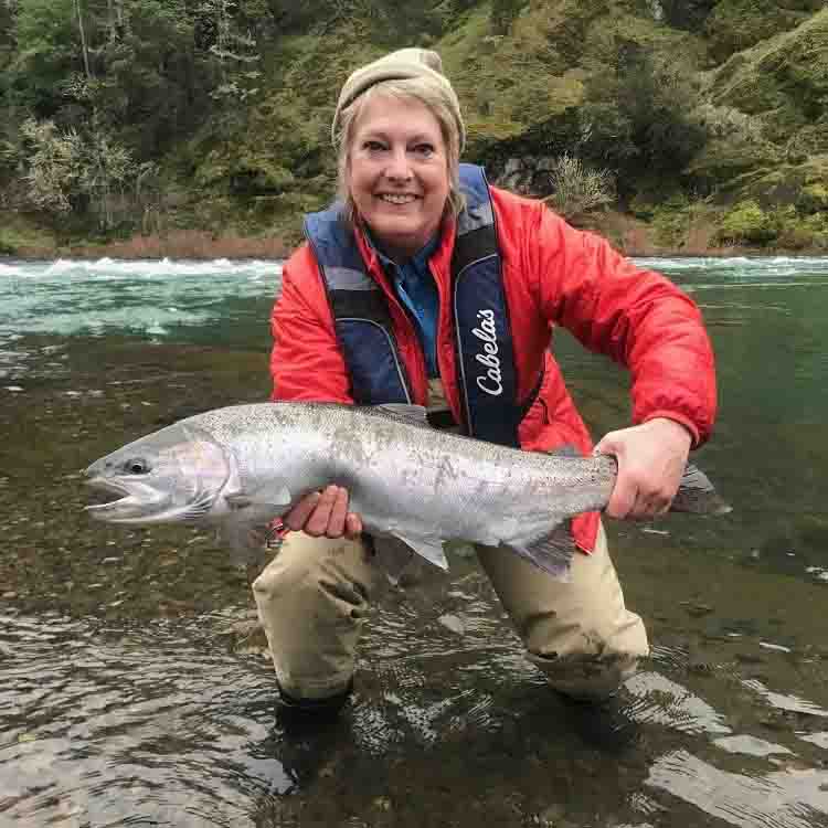 woman fly fisher holding big catch