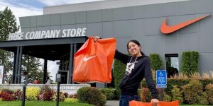 A Pass to the Nike Employee Store Young woman holding up shopping bags outside a Nike store